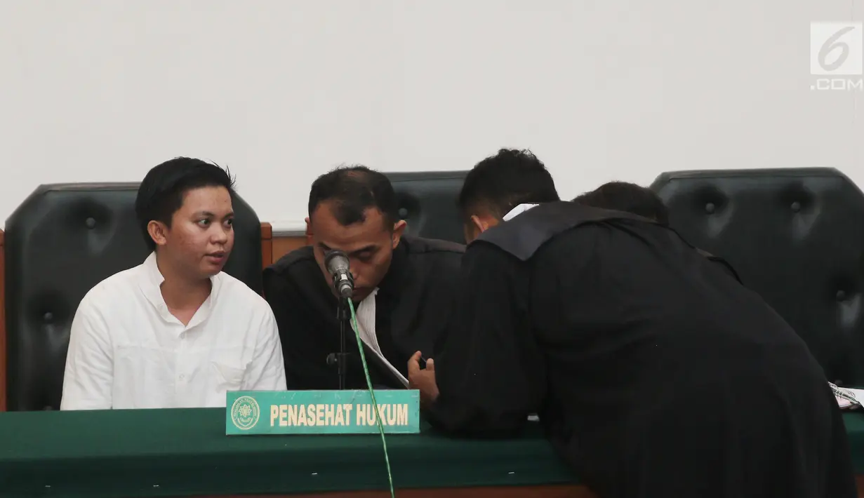 Terdakwa kasus dugaan penipuan dan penggelapan biro perjalanan umrah First Travel, Komisaris First Travel Kiki Hasibuan berbincang dengan kuasa hukunya saat menjalani sidang vonis di PN Depok, Jawa Barat, Rabu (30/5). (Liputan6.com/Herman Zakharia)