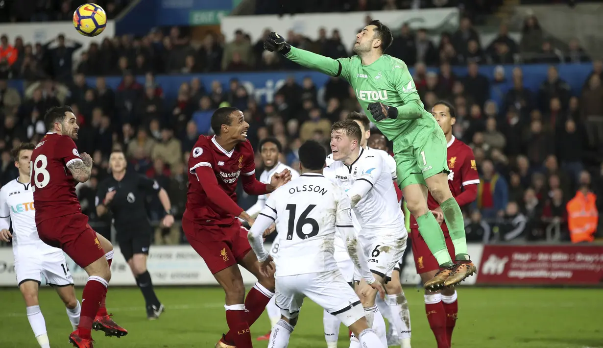 Aksi kiper Swansea City, Lukasz Fabianski menghalau bola dari jangkauan pemain Liverpool pada lanjutan Premier League di Liberty Stadium, Swansea, (22/1/2018). Liverpool kalaj dari Swansea 0-1. (Nick Potts/PA via AP)