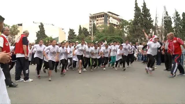 Warga kota Homs, Suriah, merayakan mundurnya pemberontak dengan kegiatan Maraton.