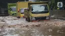 Sejumlah truk melewati banjir yang merendam terowongan di Cawang, Jakarta, Jumat (19/2/2021). Hujan yang turun sejak semalam membuat sejumlah jalanan di Ibu Kota tergenang banjir dengan ketinggian sekitar 30-50 cm. (merdeka.com/Imam Buhori)