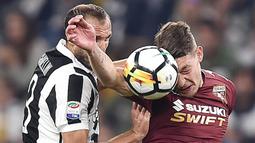 Bek Juventus, Giorgio Chiellini, duel udara dengan striker Torino, Andrea Belotti, pada laga Serie A, Italia, di Stadion Allianz, Sabtu (23/9/2017). Juventus menang 4-0 atas Torino. (AP/Alessandro Di Marco)