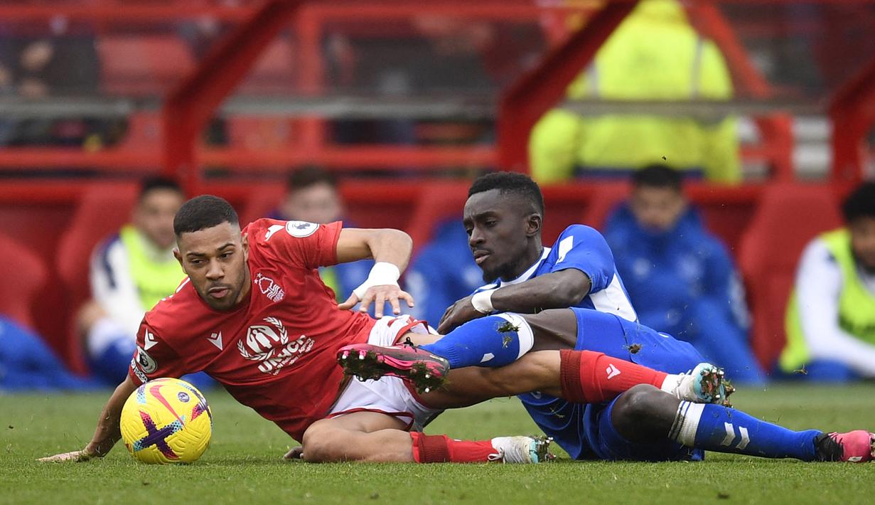 Gelandang Everton, Idrissa Gueye (kanan) dan bek Nottingham Forest, Renan Lodi terjatuh saat perebutan bola pada laga Liga Inggris 2022/2023 di City Ground, Nottingham (5/3/2023). Idrissa Gueye pernah jadi bagian PSG selama 3 musim sejak 2019/2020 hingga 2021/2022. Pada awal musim 2022/2023 ia memulai periode keduanya bersama Everton yang juga pernah dibelanya sebelum hijrah ke PSG. Bersama Alex Iwobi ia juga gagal mengangkat Everton musim ini. (AFP/Oli Scarff)