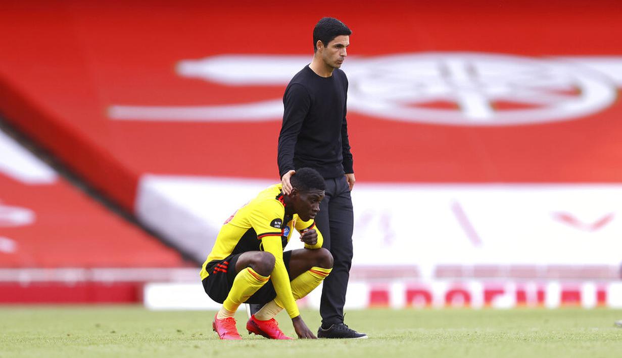 Pelatih Arsenal, Mikel Arteta, berusaha menenangkan pemain Watford,Christian Kabasele, pada laga Premier League di Stadion Emirates, Minggu (26/7/2020). Arsenal menang 3-2 atas Watford. (AP photo/ Rui Vieira, Pool)
