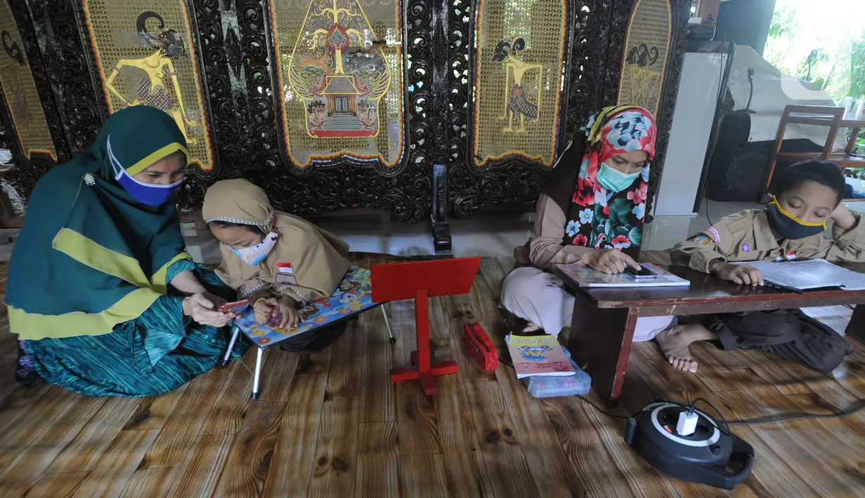 Siswa belajar secara daring menggunakan fasilitas wifi gratis di Perumahan Pondok Mulya I, Beji, Depok, Jawa Barat, Rabu (29/7/2020). Fasilitas tersebut disediakan oleh Sri Wiwoho untuk siswa sekitar perumahan. (merdeka.com/Arie Basuki)