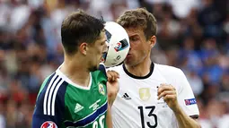 Pemain Jerman, Thomas Muller, berebut bola dengan pemain Irlandia Utara, Craig Cathcar, pada laga Grup C Piala Eropa 2016 di Parc des Princes, Paris, Selasa (21/6/2016). (AFP/Lionel Bonaventre)