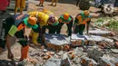 Petugas UPK Badan Air DLH Provinsi DKI Jakarta memindahkan puing saat memperbaiki tembok Kali Krukut yang jebol di Jalan Taman Kemang, Jakarta, Selasa (23/2/2021). Jebolnya tembok tersebut mengakibatkan kawasan kemang dan sekitarnya terendam banjir pada 20 Februari 2021. (Liputan6.com/Faizal Fanani)