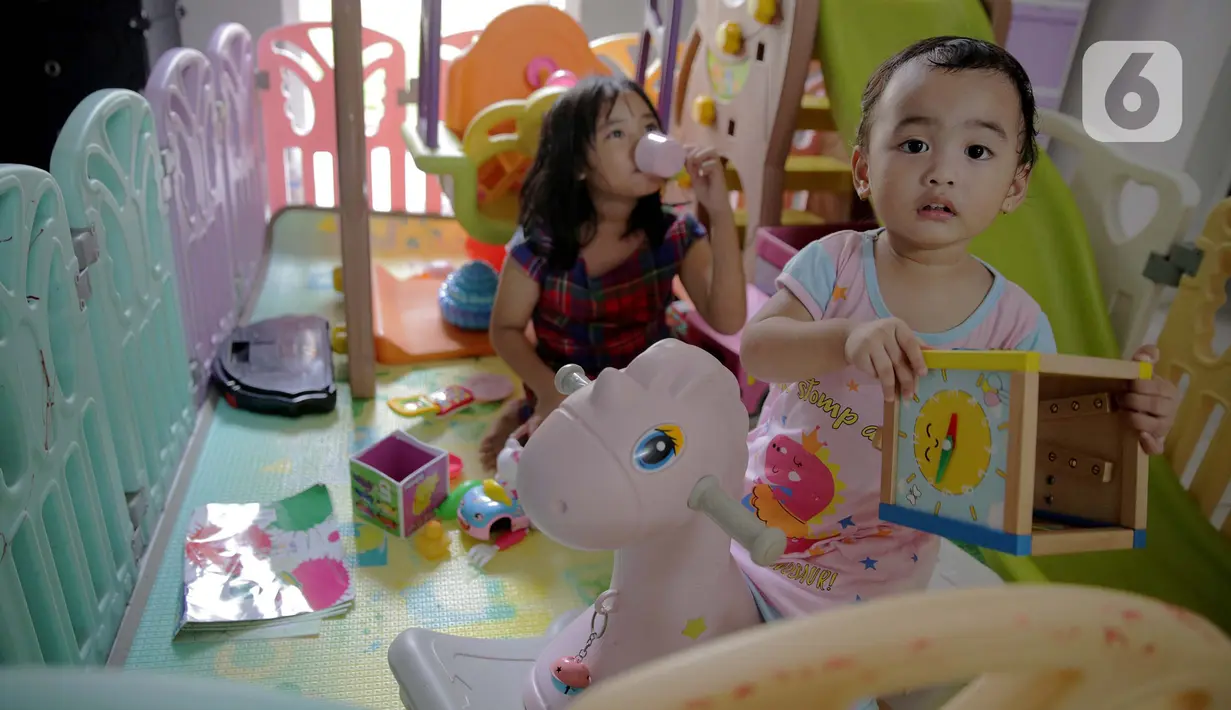 Dua orang anak bermain di dalam rumah di Kawasan Jakarta, Minggu (29/3/2020). Aktivitas bermain di dalam rumah saat ini menjadi alternatif warga dalam mengurangi interaksi sosial sebagai upaya pencegahan penyebaran virus corona atau COVID-19. (Liputan6.com/Faizal Fanani)