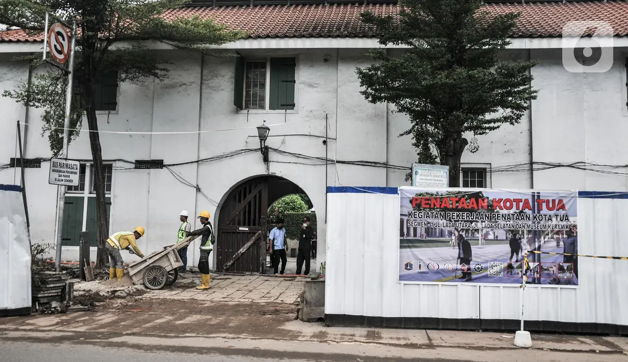 Aktivitas pekerja menyelesaikan proyek revitalisasi fasilitas pejalan kaki atau pedestrian kawasan Kota Tua, Jakarta, Minggu (27/3/2022). Jalur pedestrian itu akan diubah menjadi plaza pedestrian yang lebar sebagai bagian dari penataan kawasan Kota Tua yang rendah emisi (merdeka.com/Iqbal S Nugroho)