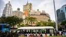 Wisatawan antre untuk menaiki bus dengan latar belakang resor kasino Grand Lisboa (tengah) di Macau, 5 Maret 2019. Hampir setengah PDB Macau atau sekitar 45 miliar dolar AS bersumber dari perjudian. (Anthony Wallace/AFP)