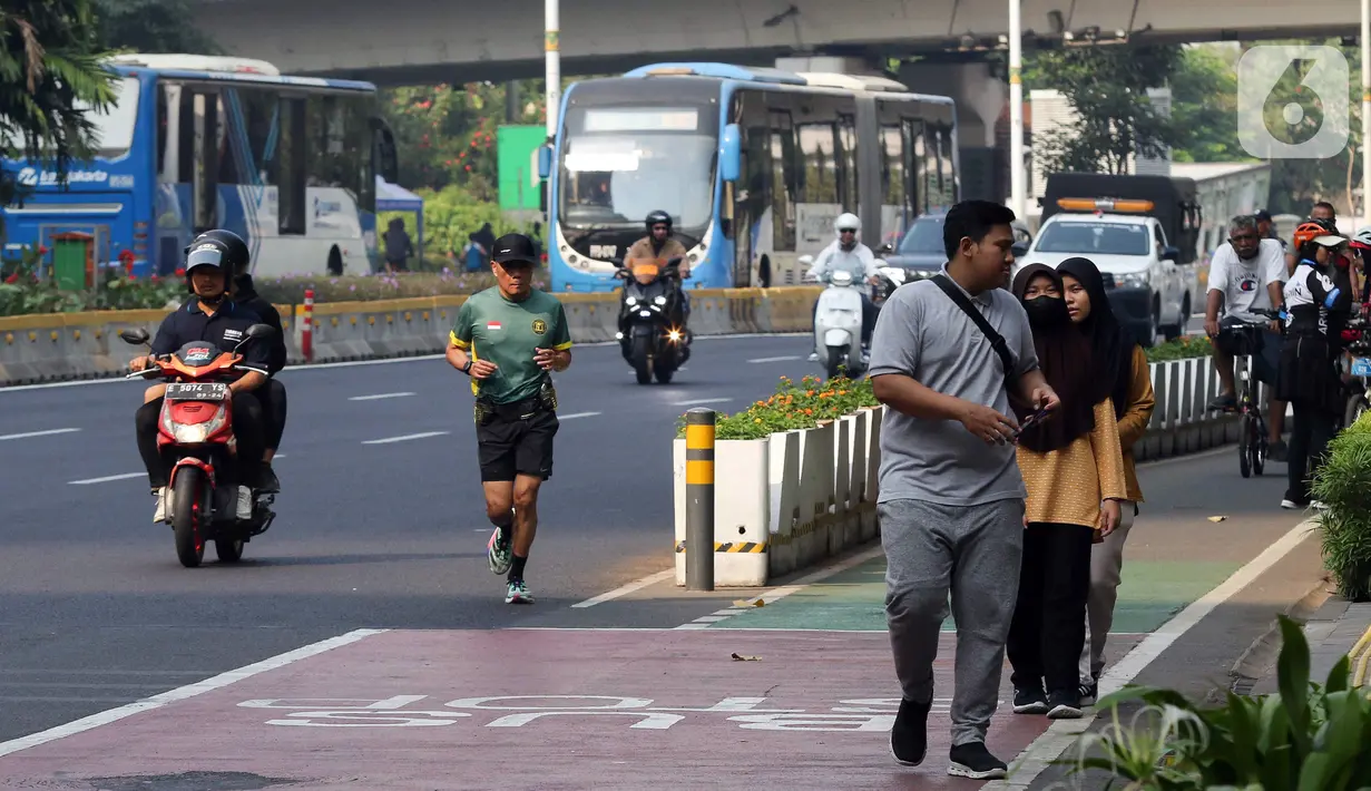 Terlihat juga beberapa mobil patwal polisi menjaga di sekitar Bundaran HI. Kendaraan bermotor juga tampak lalu lalang. (Liputan6.com/Herman Zakharia)