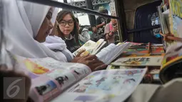 Sejumlah pelajar membaca buku di Perpustakaan Bemo yang terparkir di RTPRA Kalijodo, Jakarta, Selasa (2/5). Pesta Pendidikan di RPTRA Kalijodo hadirkan bemo perpustakaan untuk meningkatkan minat baca para pengunjung. (Liputan6.com/Yoppy Renato)