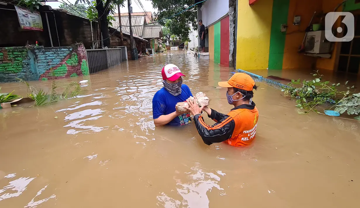 Petugas PPSU memberi bantuan nasi bungkus kepada warga yang bertahan saat banjir di kawasan pemukiman Jalan Bango, Pondok Labu, Jakarta Selatan, Sabtu (20/2/2021). Banjir akibat luapan Kali Krukut yang melanda sejak semalam menyebabkan pemukiman tergenang hingga dua meter. (merdeka.com/Arie Basuki)