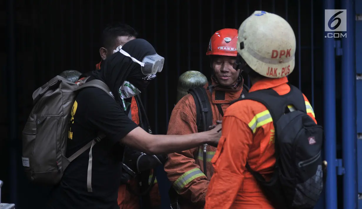 Petugas pemadam saat mengevakuasi salah seorang korban selamat (kaos hitam) dari lokasi kebakaran di Gedung Kemenhub, Jakarta, Minggu (8/7). Hingga saat ini petugas kepolisian masih menyelidiki penyebab kebakaran tersebut. (Merdeka.com/Iqbal S Nugroho)