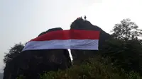 Bendera berukuran besar kembali dikibarkan di Gunung Munara (Liputan6.com/ Achmad Sudarno)