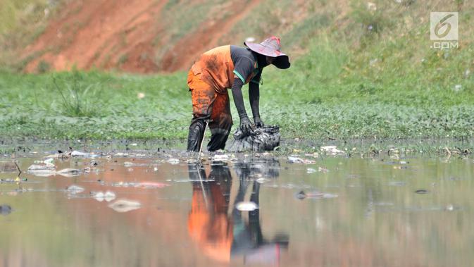 Petugas PPSU dan Sudin Tata Air Jakarta Timur membersihkan sampah dan tanaman liar di sepanjang aliran Kanal Banjir Timur (KBT), Senin (15/10). Aksi dilakukan guna mengantisipasi banjir sekaligus mempercantik kawasan KBT. (Merdeka.com/ Iqbal S. Nugroho)