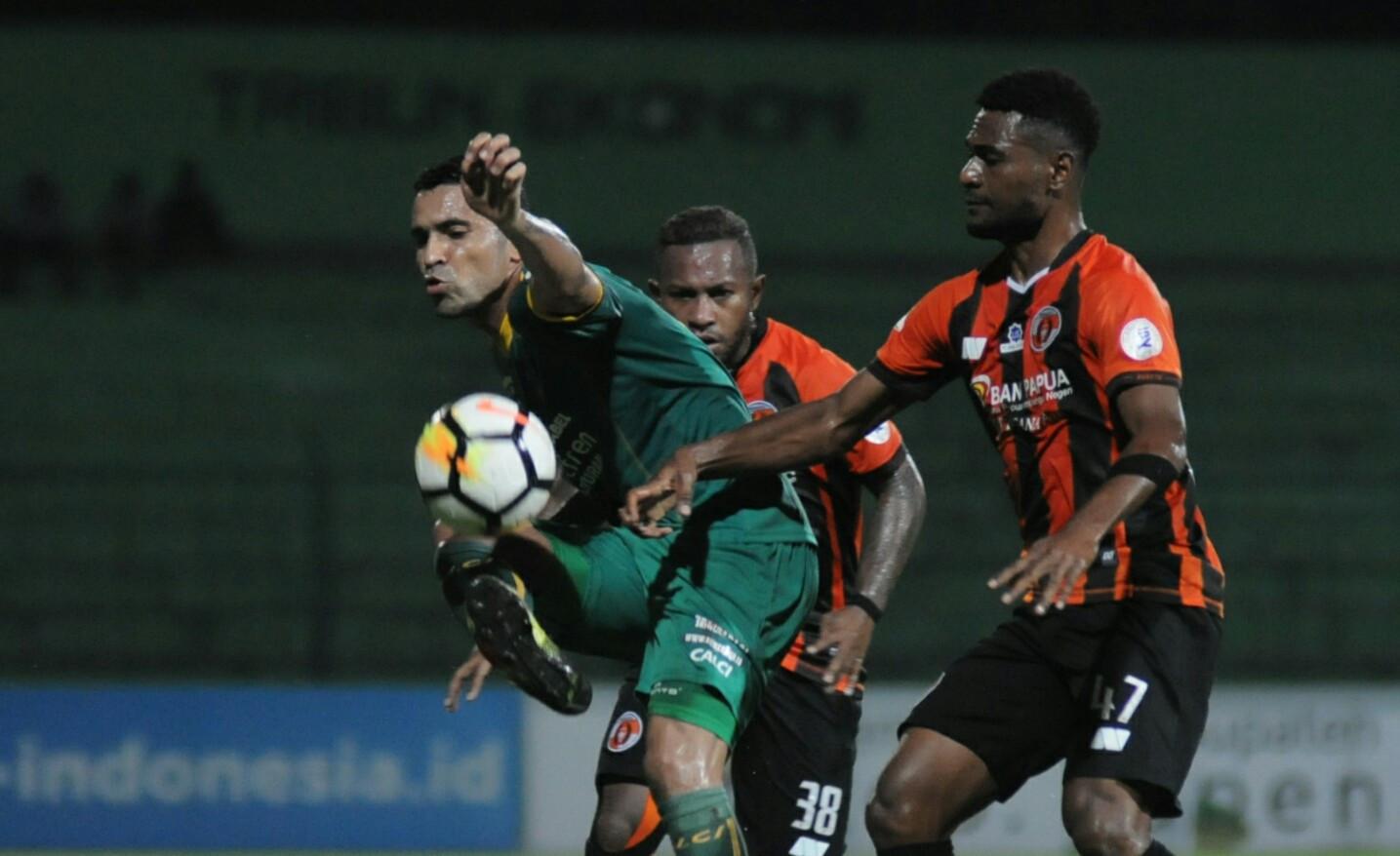 Striker Sriwijaya FC, Beto Goncalves, berduel dengan dua pemain Perseru Serui di Stadion Gajayana, Malang, Minggu (27/5/2018). (Bola.com/Iwan Setiawan)