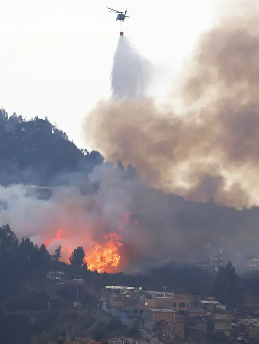 Helikopter dikerahkan untuk memadamkan api di daerah perbukitan dekat Bogota , Kolombia, 2 Februari 2016 Kebakaran hutan ini terjadi hanya beberapa meter dari pemukiman penduduk. (REUTERS / John Vizcaino)