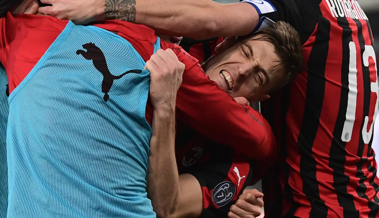 Striker AC Milan Krzysztof Piatek dipeluk rekan setimnya usai mencetak gol ke gawang Chievo pada pekan ke-27 Liga Italia di Stadion Marcantonio Bentegodi, Verona, Sabtu (9/3). Piatek mencetak gol penentu untuk kemenangan AC Milan. (Miguel MEDINA/AFP)