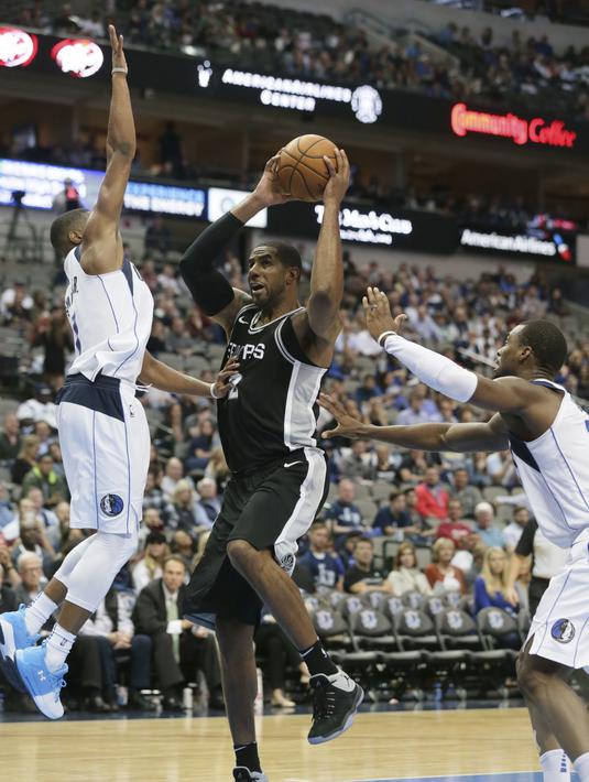 Pemain San Antonio Spurs, LaMarcus Aldridge (12) mencoba melewati adangan dua pemain Dallas Mavericks pada laga NBA Basketball game di American Airlines Center, Dallas, (14/11/2017). Spurs menang 97-91. (AP/LM Otero)
