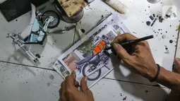 Pengrajin Wawang Kurniawan, membuat cetakan miniatur motor RX-King di Kampung Dukuh, Serua, Tangerang Selatan, Sabtu (17/10/2020). Selama masa pandemi Covid-19, miniatur motor yang dijual dengan harga Rp400 - 500 ribu per buah tidak mengalami penurunan omset. (Liputan6.com/Fery Pradolo)