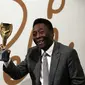 Mantan pemain timnas Brasil Pele memegang replika trofi Jules Rimet. Trofi ini diberikan kepada pemenang Piala dunia. (ADRIAN DENNIS / AFP)