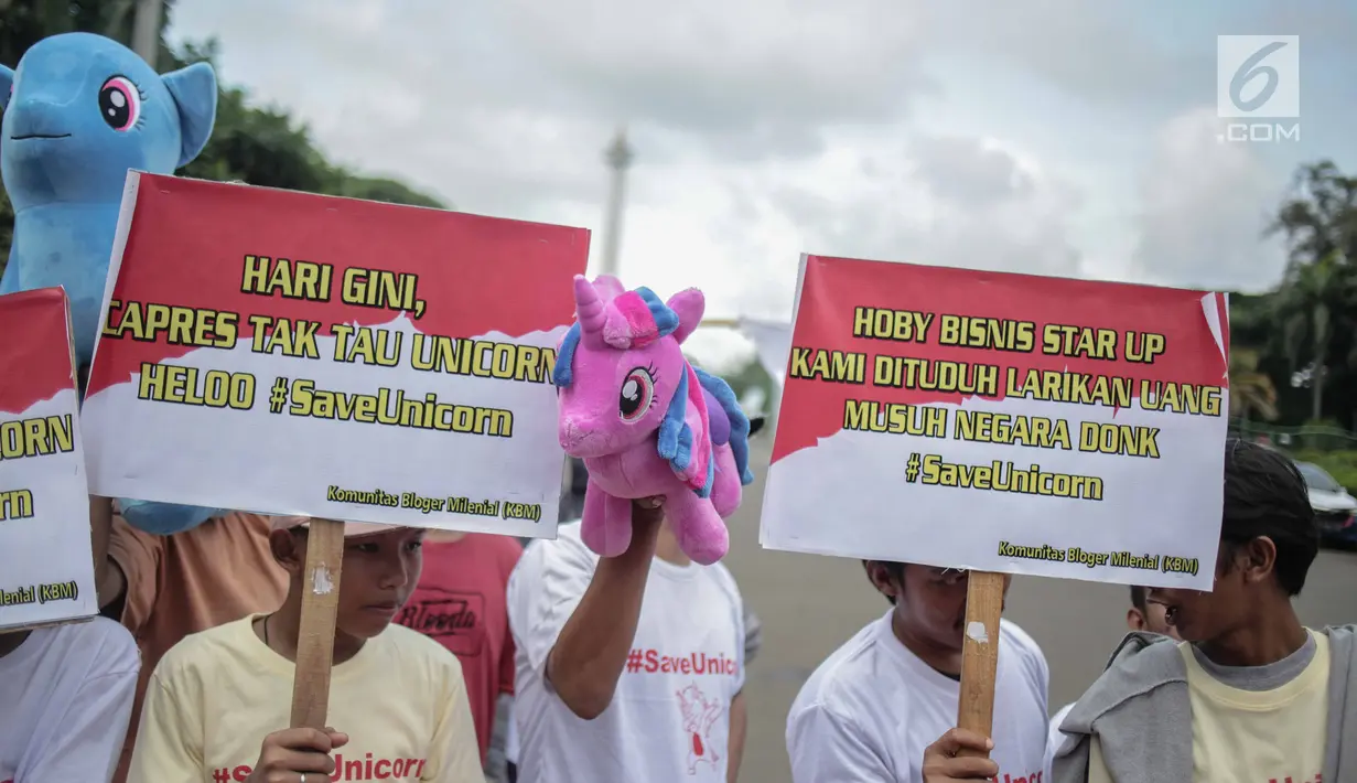 Puluhan massa yang tergabung dalam Komunitas Blogger Milenial (KBM) menggelar aksi #SaveUnicorn di Jakarta, Selasa (19/2). Massa membawa sejumlah spanduk dan boneka unicorn. (Liputan6.com/Faizal Fanani)