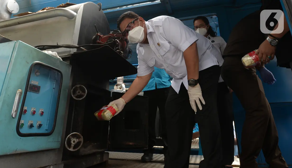 Kepala Badan Narkotika Nasional (BNN) Komisaris Jenderal Polisi Petrus Reinhard Golose memasukkan barang bukti narkotika pada mesin pembakar limbah berbahaya (incenerator) saat pemusnahan barang bukti hasil sitaan di Kantor BNN, Jakarta, Selasa (25/5/2021). (merdeka.com/Imam Buhori)