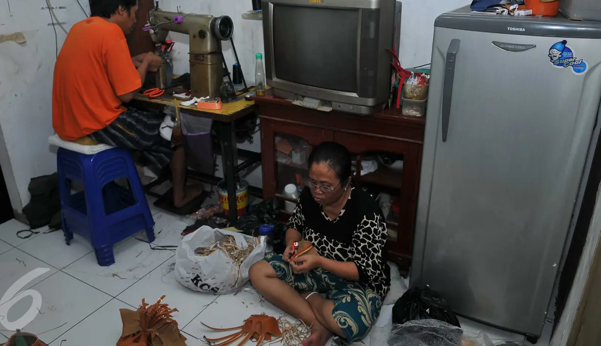Warga kalijodo yang sedang membuat sepatu disalah satu rumah produksi di Jakarta, Selasa (16/2). Warga Kalijodo banyak yang memilki UKM sendiri untuk mendapatkan penghasilan yang halal. (Liputan6.com/Gempur M Surya)