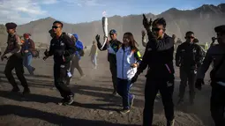 Legenda bulu tangkis Indonesia, Susi Susanti (tengah) membawa obor Asian Games 2018 di Gunung Bromo, Probolinggo, Jawa Timur, Sabtu (21/7). Sekitar 11 ribu atlet dari 45 negara Asia akan mengikuti Asian Games 2018. (JUNI KRISWANTO/AFP)