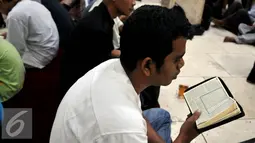 Sejumlah warga tampak membaca Alquran saat menunggu waktu berbuka puasa di Masjid Istiqlal, Jakarta (22/6/2015). Sekitar 3000 kotak makanan dan minuman dibagikan setiap harinya selama bulan Ramadan. (Liputan6.com/JohanTallo)
