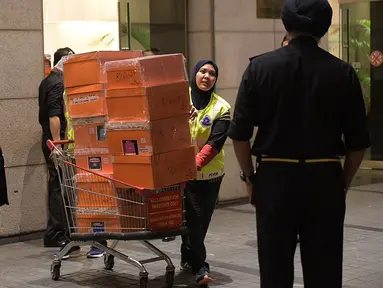 Polisi Malaysia membawa tas mewah yang disita dalam penggeledahan di tiga apartemen mantan Perdana Menteri, Najib Razak di Kuala Lumpur, Jumat (18/5). Polisi menyita 284 tas tangan mewah termasuk Hermes dan Birkin. (ARIFFIN JAMAR/THE STRAITS TIMES/AFP)