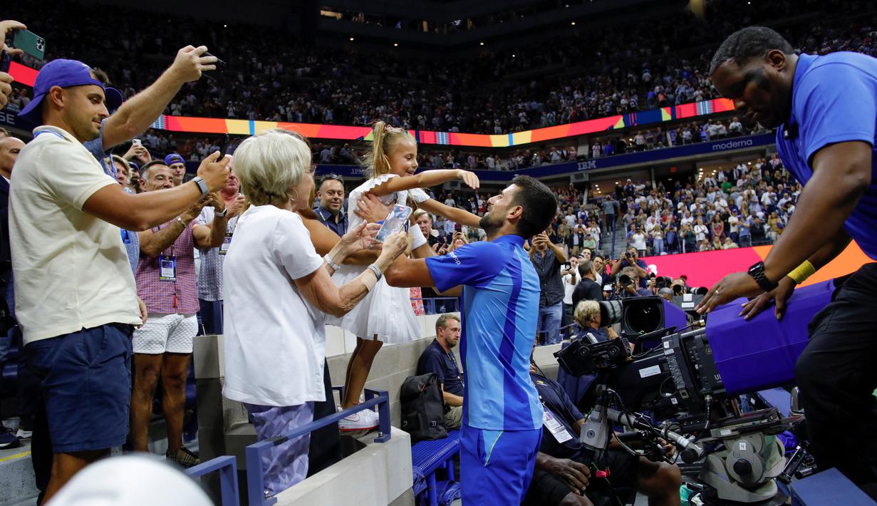 Petenis asal Serbia, Novak Djokovic (tengah), menghampiri putrinya, Tara, yang berada di tribun penonton setelah mengalahkan petenis asal Rusia Daniil Medvedev dalam partai final US Open 2023 yang berlangsung di Arthur Ashe, New York, Senin (11/9/2023) pagi WIB. (AFP/Kena Betancur)