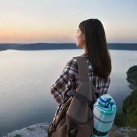 Seorang perempuan sedang menikmati sunset di tepi tebing (Foto Dok: Freepik/serhii_bobyk).