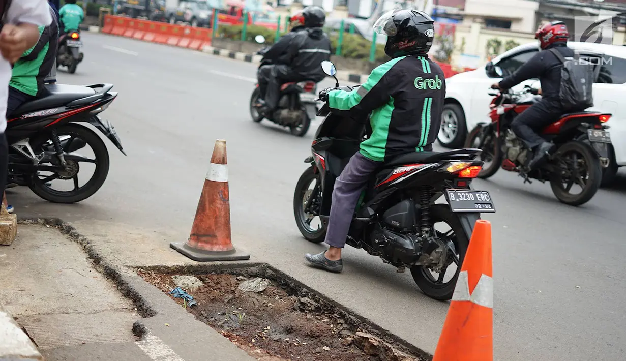 Kendaraan melintas di samping bekas galian proyek yang tidak tuntas pengerjaannya di Jalan Margonda Raya, Depok, Jawa Barat, Kamis (9/5/2019). Kondisi jalan yang diabaikan selama beberapa bulan terakhir tersebut memersempit dan mengganggu aktivitas warga. (Liputan6.com/Immanuel Antonius)