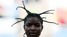 Pesepak bola wanita asal Zimbabwe, Marjory Nyaumw bersiap bertanding melawan Kanada di Grup F Olimpiade Rio 2016 di Korintus Arena, Brasil, (6/8). Atlet 29 tahun ini mengepang rambut gimbalnya ke atas yang jadi sorotan. (AFP PHOTO/Miguel SCHINCARIOL)