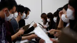 Sejumlah peserta pria dan wanita berbincang saat mengikuti acara layanan kencan di Tokyo, Jepang, (16/10). Peserta diwajibkan menggunakan masker saat memperkenalkan diri satu sama lain. (REUTERS/Kim Kyung-Hoon)