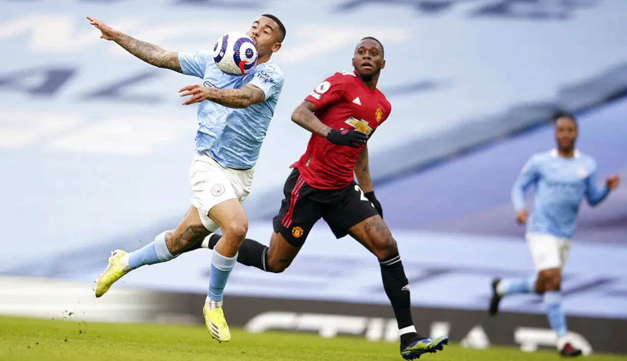 Pemain Manchester United Aaron Wan-Bissaka (kanan) memperebutkan bola dengan pemain Manchester City Gabriel Jesus pada pertandingan Liga Inggris di Etihad Stadium, Manchester, Inggris, Minggu (7/3/2021). Manchester United mempermalukan Manchester City dengan skor 2-0. (Dave Thompson/Pool via AP)