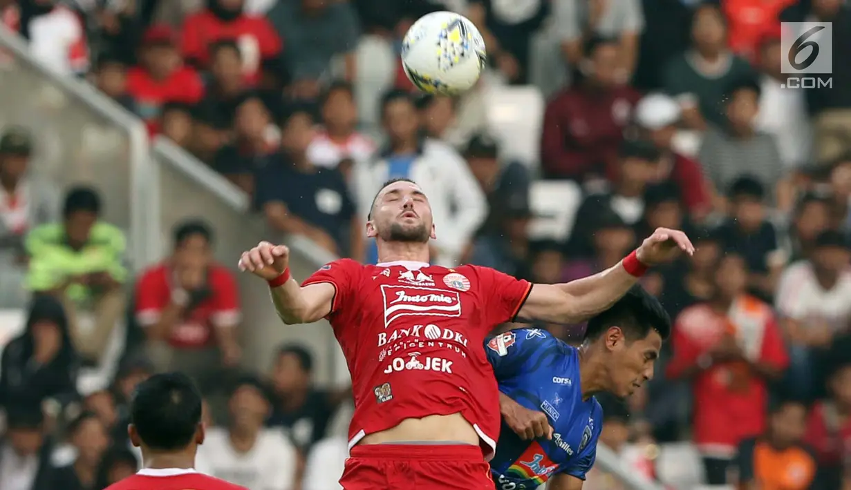 Pemain depan Persija, Marko Simic berebut bola atas dengan bek Arema FC, Hanif Abdurrauf Sjahbandi pada lanjutan Shopee Liga 1 Indonesia 2019 di Stadion Gelora Bung Karno, Jakarta, Sabtu (3/8/2019). Laga berakhir imbang 2-2. (Liputan6.com/Helmi Fithriansyah)