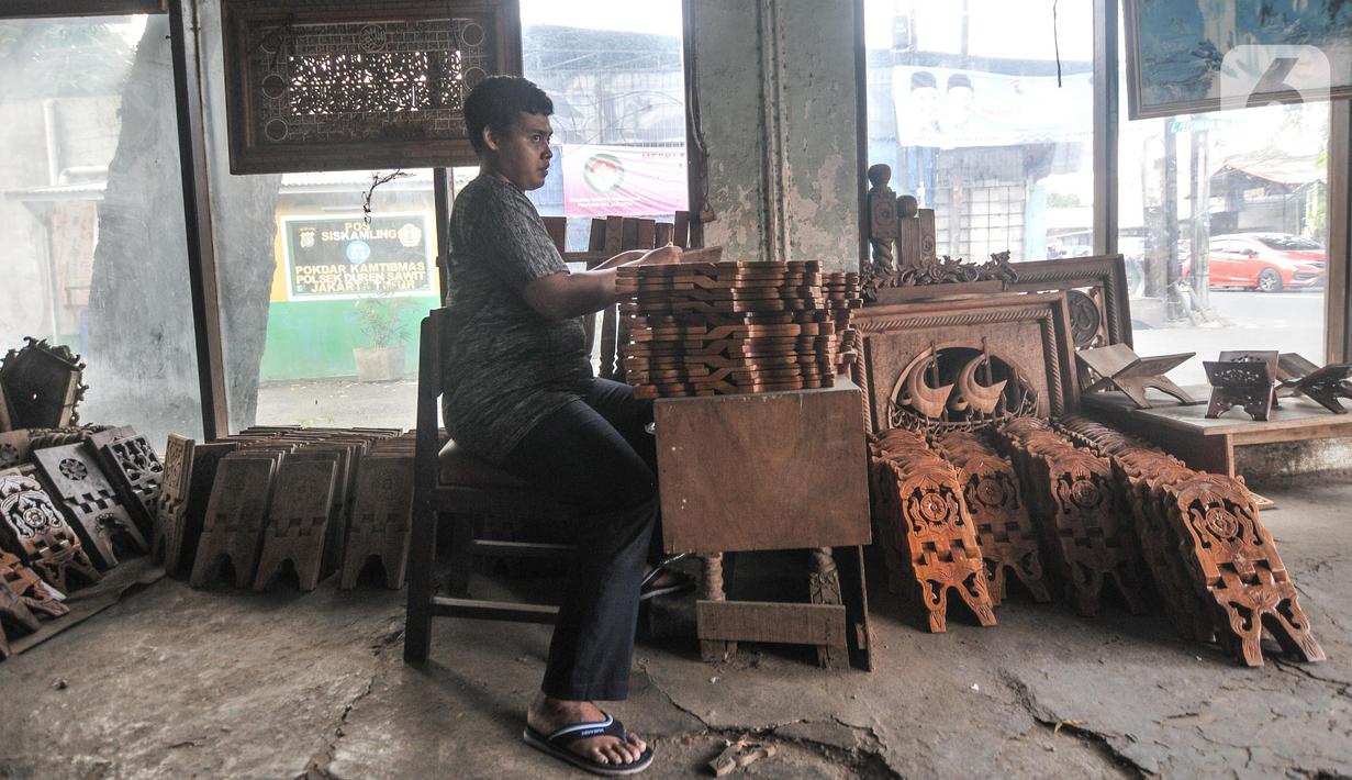 Pekerja menyelesaikan pembuatan rehal atau meja untuk Al-qur’an di Toko Mabruri 12, Klender, Jakarta, Rabu (13/4/2022). Harga rehal di toko ini dibanderol mulai dari Rp50.000 hingga Rp300 ribu per buah, tergantung ukuran dan jenis kayu. (merdeka.com/Iqbal S Nugroho)