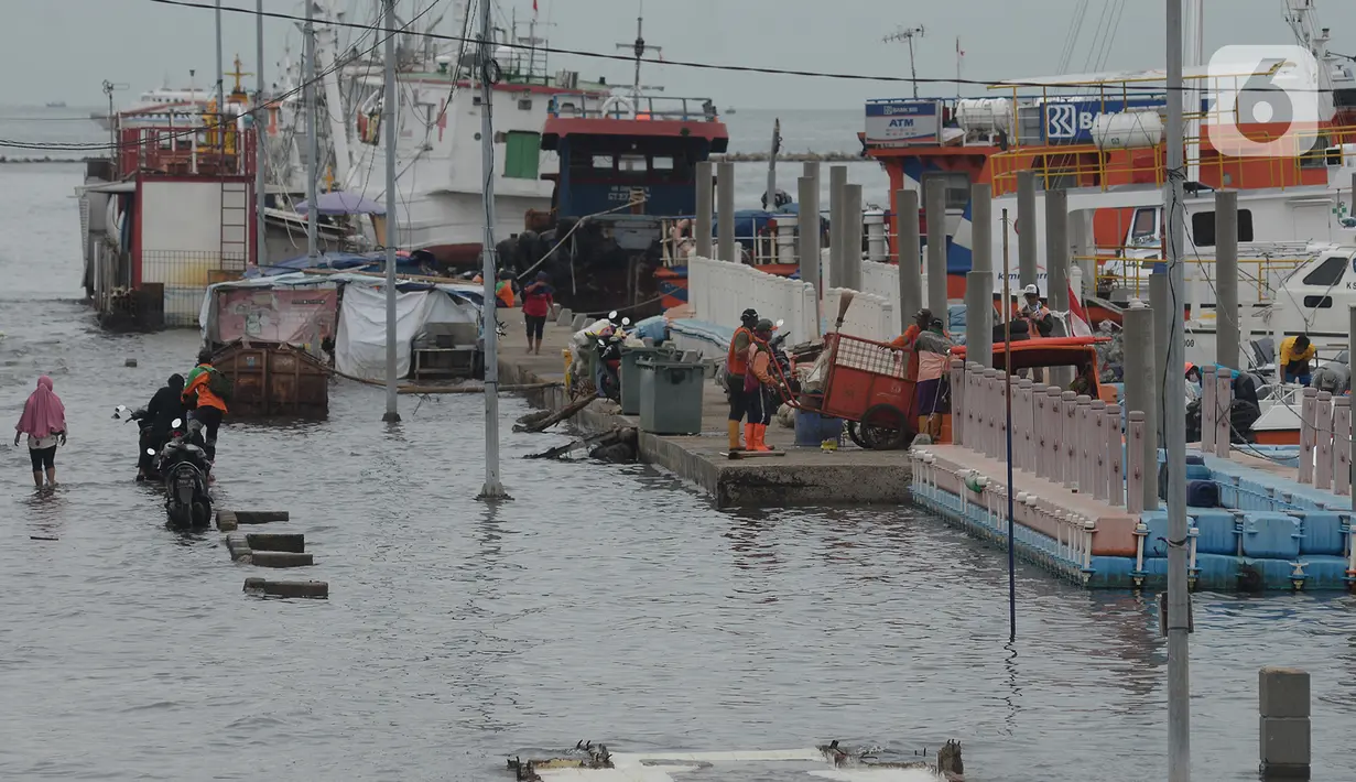 Warga beraktivitas di dermaga pelabuhan kali Adem, Muara Angke, Jakarta, Kamis (31/12/2020). Badan Meteorologi Klimatologi dan Geofisika (BMKG) memberikan peringatan dini cuaca akan berpotensi hujan disertai angin kencang dan kilat/petir menjelang pergantian tahun. (merdeka.com/Imam Buhori)