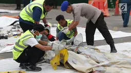 Petugas mengecek dan mengidentifikasi barang property pesawat Lion Air PK-LQP JT 610 di Pelabuhan JICT 2, Jakarta, Senin (5/11). Sejumlah barang ditemukan petugas gabungan dalam operasi pencarian. (Liputan6.com/Helmi Fithriansyah)