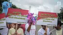 Puluhan massa yang tergabung dalam Komunitas Blogger Milenial (KBM) menggelar aksi #SaveUnicorn di Jakarta, Selasa (19/2). Massa membawa sejumlah spanduk dan boneka unicorn. (Liputan6.com/Faizal Fanani)