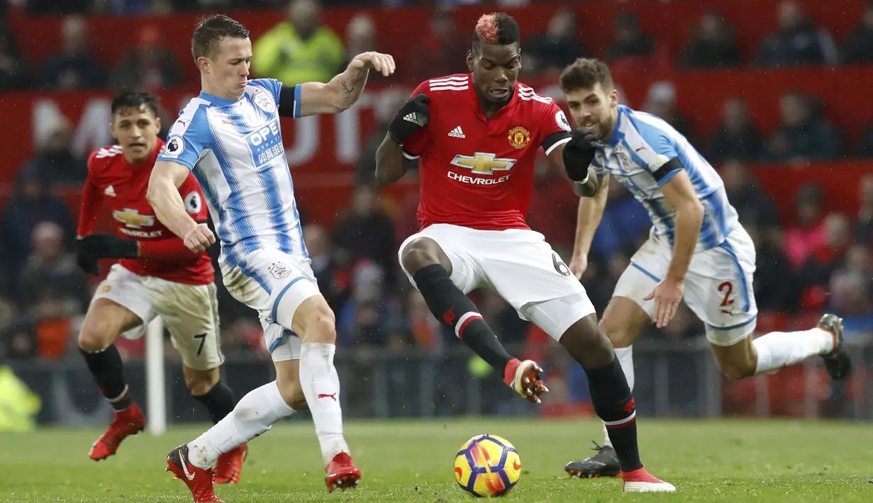 Para pemain Huddersfield Town mencoba menghentikan Paul Pogba (tengah) pada laga Premier League di Old Trafford, Manchester, (3/2/2018). MU menang 2-0. (Martin Rickett/PA via AP)