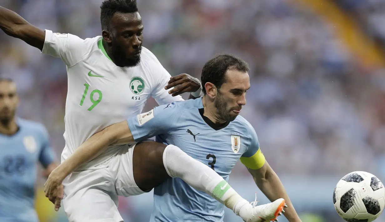 Aksi pemain Arab Saudi, Fahad Almuwallad (kiri) menghalau bola dari pemain Uruguay, Diego Godin pada laga grup A Piala Dunia 2018 di Rostov Arena, Rostov-on-Don, Rusia, (20/6/2018). Uruguay menang 1-0. (AP/Andrew Medichini)