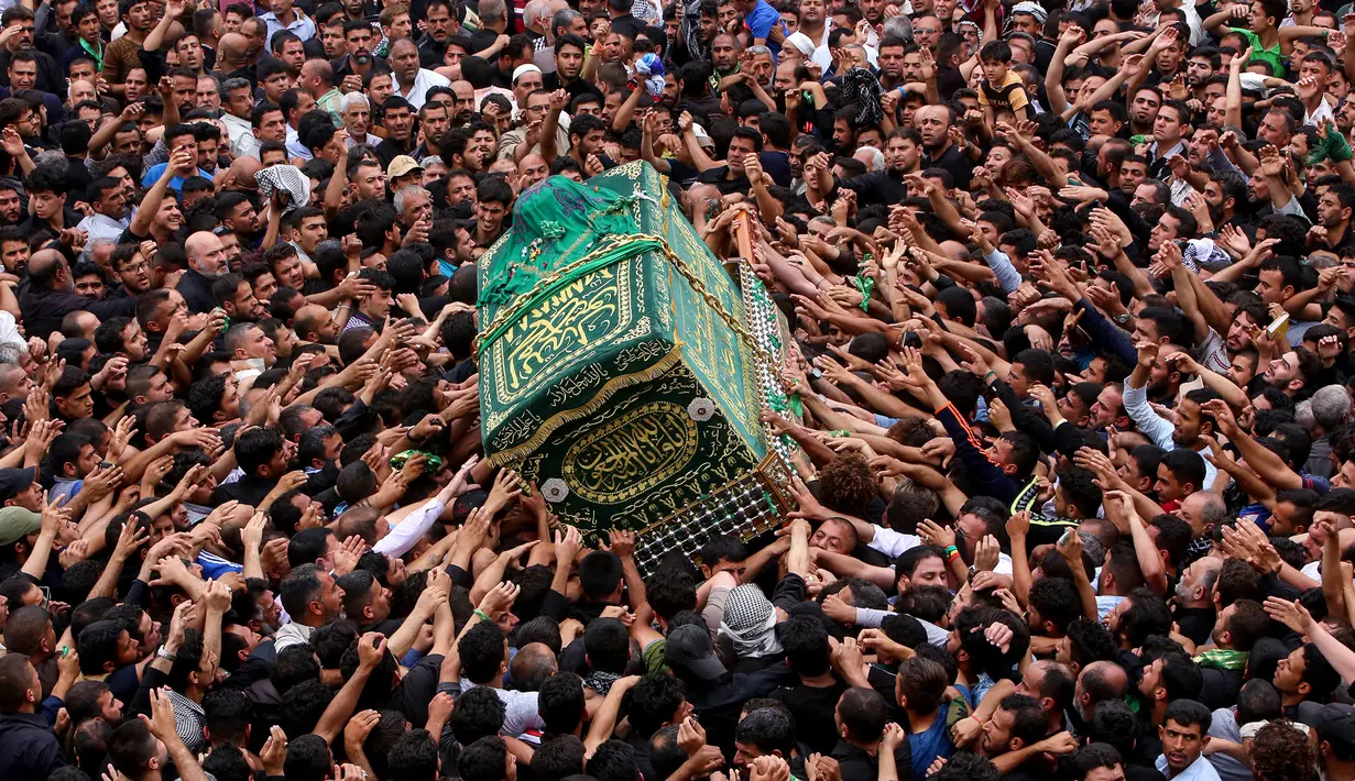 Umat Syiah Irak membawa peti jenazah saat memperingati wafatnya Imam Musa al-Kadhim di Kadhimiya, distrik utara Baghdad, Irak (23/4). Imam Musa al-Kadhim adalah imam ketujuh dari 12 imam Syiah yang meninggal pada 799. (AFP/Sabar Arar)