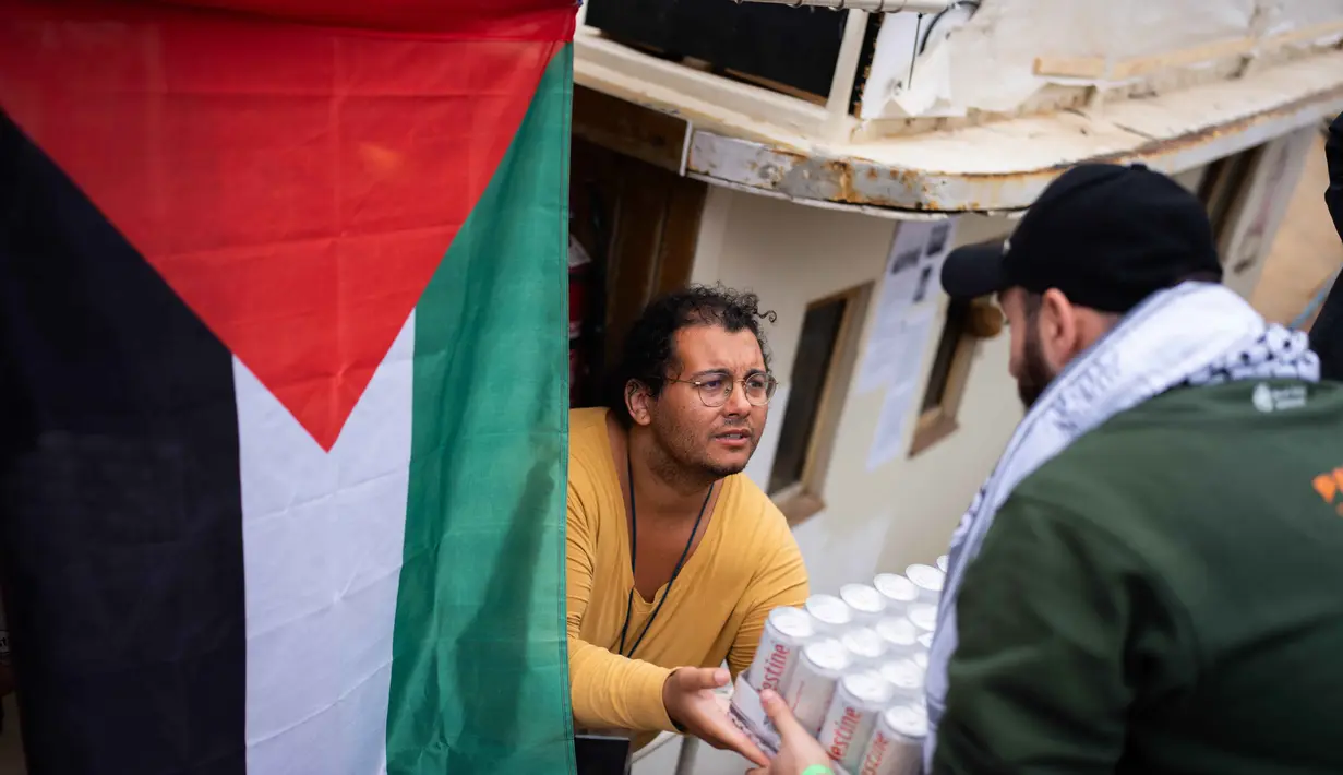 Dikenal sebagai Global Sumud Flotilla 2.0, misi ini melibatkan lebih dari 100 kapal dari 100 negara dengan sekitar 3.000 peserta, menjadikannya dua kali lebih besar dari misi sebelumnya di tahun 2025. Tampak dalam foto, para aktivis menyiapkan perbekalan di atas kapal yang ikut serta dalam Armada Global Sumud yang menuju Gaza, di Barcelona, Spanyol, Minggu, 12 April 2026. (AP Photo/Joan Mateu Parra)