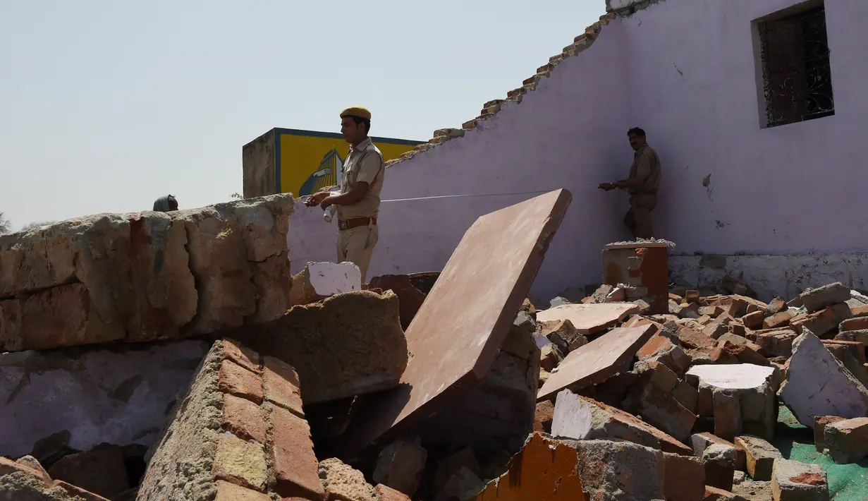 Polisi India melakukan olah lokasi gedung yang dijadikan pesta pernikahan di Rajashtan, Kamis (11/5). Sedikitnya 24 orang tewas dan melukai puluhan lainnya pada pesta pernikahan setelah tembok bangunan ambruk dan menimpa para tamu. (MONEY SHARMA/AFP)