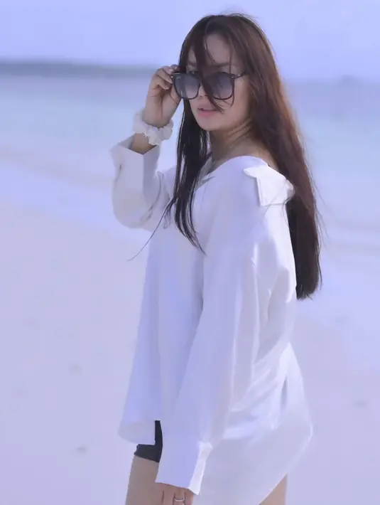 Tampil mengenakan kemeja putih yang senada dengan putihnya pasir pantai, membuat hasil pemotretannya terlihat menakjubkan. Banyak dari para penggemar yang mendoakan agar kisah asmaranya tidak banyak berliku seperti dulu. (Liputan6.com/IG/@kalinaocktaranny)