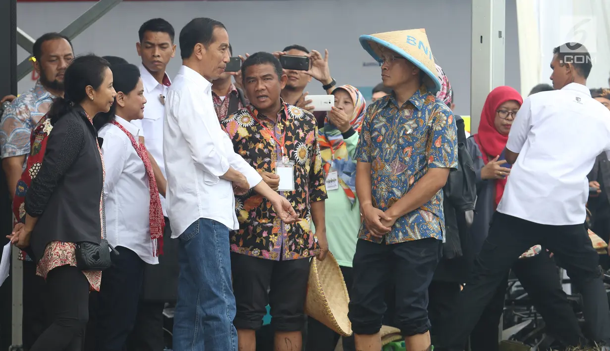 Presiden Joko Widodo didampingi Ibu Negara Iriana dan Menteri BUMN Rini Soemarno saat blusukan ke area persawahan untuk meninjau Gerakan Mengawal Musim Tanam Okmar 2018/2019 di Desa Leuwigoong, Garut, Jawa Barat, Sabtu (19/1). (Liputan6.com/Angga Yuniar)