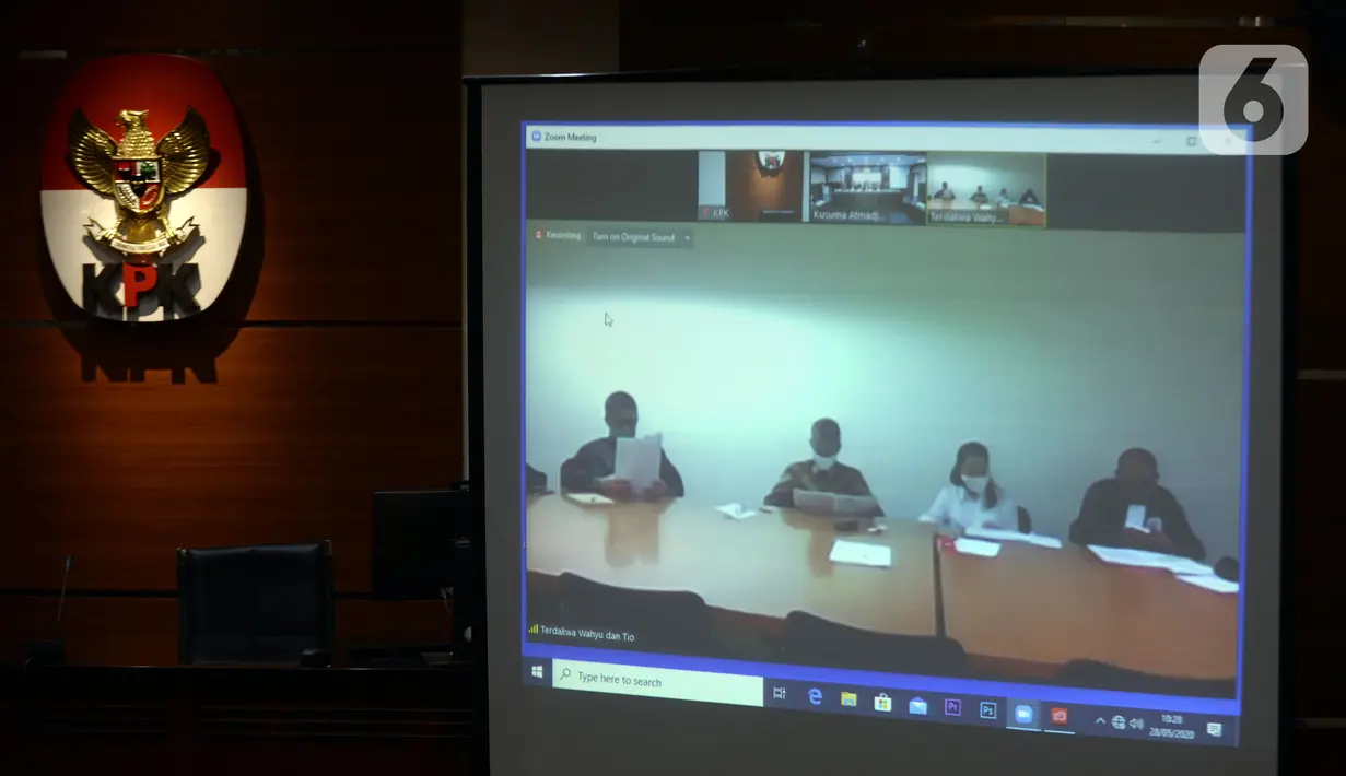 Mantan Komisioner KPU Wahyu Setiawan (kedua kiri) mendengarkan Jaksa Penutut Umum membacakan dakwaan saat sidang secara daring di Gedung KPK, Jakarta, Kamis (28/5/2020). Wahyu menjalani sidang dakwaan terkait kasus dugaan menerima suap pengurusan PAW anggota DPR dari PDIP. (merdeka.com/Dwi Narwoko)